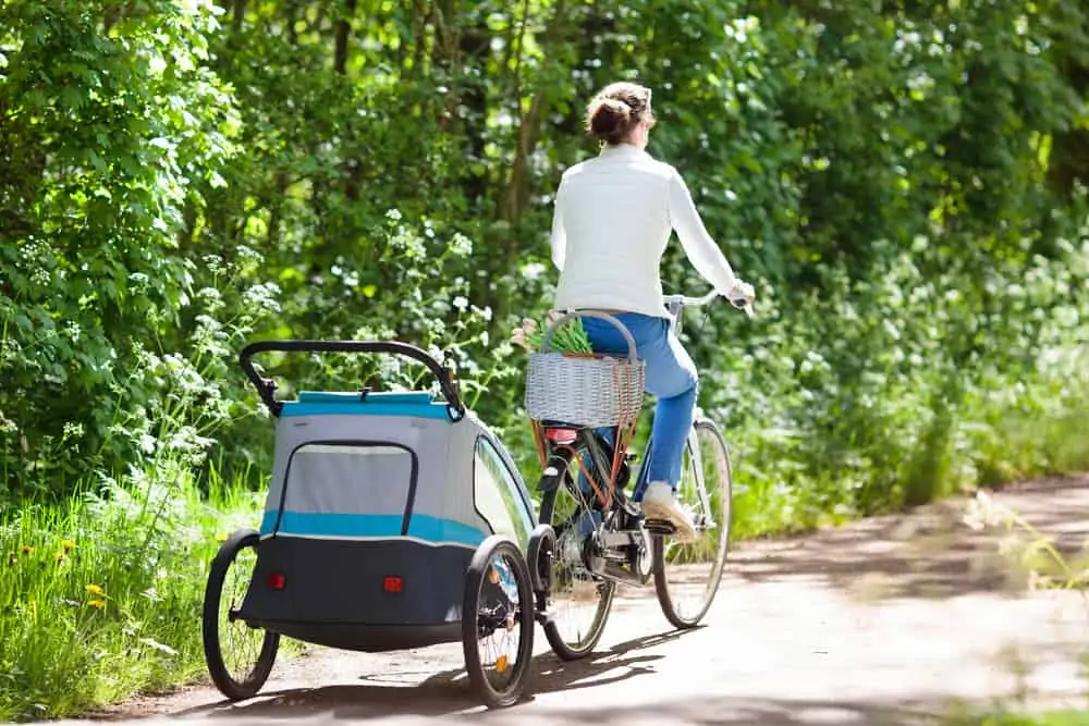 Woman riding bike, biking with a baby carrier