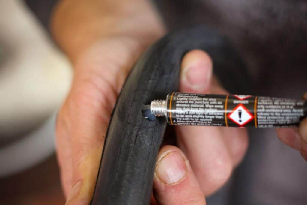image of how to fix a bike tube applying vulcanizing fluid